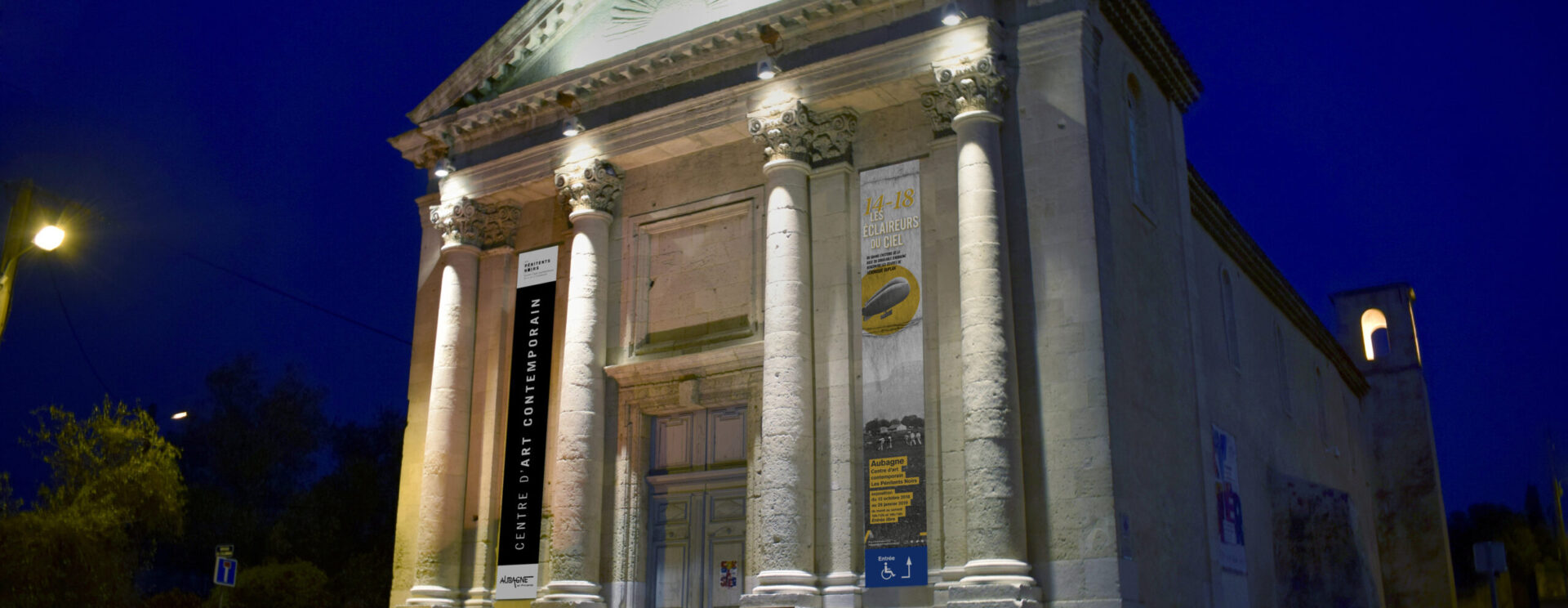 Photo de la façade de nuit du centre d'art Les Pénitents Noirs